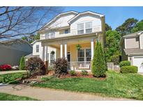 Beautiful two-story home featuring a cozy front porch with seating and a lush, well-maintained lawn at 7807 Chaddsley Dr, Huntersville, NC 28078