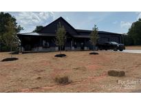 Stunning black exterior home featuring a manicured yard, modern design, and spacious driveway with a black truck at 108 Winners Cir # 5, Mooresville, NC 28117