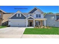 Charming two-story home with a manicured lawn, a two-car garage, and lovely stone detailing at 116 Asmodean Ln, Troutman, NC 28166