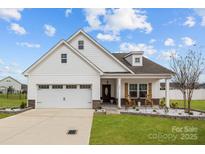 Charming single-Gathering home featuring white siding, a two-car garage, and a welcoming front porch at 1205 Brooksland Pl, Waxhaw, NC 28173
