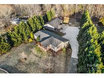 Expansive aerial view of a home with a driveway, basketball court, and lush green trees, offering a peaceful retreat at 126 Goat Trl, China Grove, NC 28023