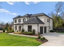 Elegant white brick home features a manicured lawn, dark shutters, and a convenient two-car attached garage at 300 Mammoth Oaks Dr, Charlotte, NC 28270