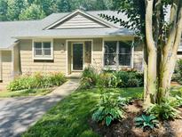 Charming single-story home featuring a well-manicured lawn and colorful flower beds enhancing the curb appeal at 413 19Th Avenue Ne Ct, Hickory, NC 28601