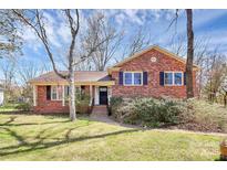 Charming brick home with a manicured lawn, mature trees, and inviting curb appeal at 6500 Windyrush Rd, Charlotte, NC 28226