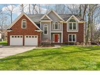 Charming brick and gray home with a red front door and manicured lawn offers classic curb appeal at 1916 Dugan Dr, Charlotte, NC 28270