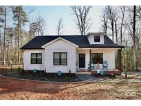 Charming single-story home boasts a welcoming front porch and manicured landscape at 357 Woodrun Dr, Mount Gilead, NC 27306