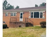 Charming single-story brick home with a front yard and inviting entrance stairs with black railing at 40359 Barnhardt Rd, New London, NC 28127