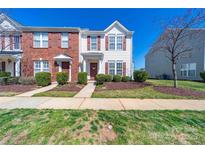 Charming two-story townhome with red shutters and a landscaped front yard on a bright, sunny day at 4221 Coulter Xing, Charlotte, NC 28213