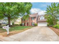 Charming two-story brick home featuring a well-manicured lawn and a long driveway at 111 Harris Farm Rd, Mooresville, NC 28115