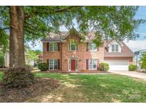 Charming two-story brick home with a well-manicured lawn and mature tree providing shade at 111 Harris Farm Rd, Mooresville, NC 28115