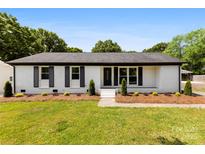 Charming single-story home featuring a well-maintained lawn and a classic white brick facade with black shutters at 1316 Fox Run Dr, Charlotte, NC 28212