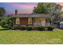 Charming brick home featuring a cozy front porch and well-manicured landscaping in a beautiful neighborhood at 404 E 1St St, Cherryville, NC 28021