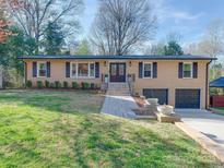 Charming brick home featuring a manicured lawn, double garage, and inviting front entrance at 4216 Maureen Dr, Charlotte, NC 28205