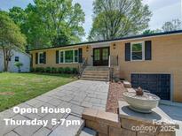 Charming brick home with stone walkway, manicured lawn, and professionally landscaped front yard at 4216 Maureen Dr, Charlotte, NC 28205