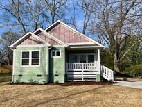 Charming green house with pink gable and front porch and white trim at 7 Private St, York, SC 29745