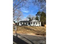 Charming single-story home featuring white painted brick, black shutters, and a well-manicured lawn at 8142 Cliffside Dr, Charlotte, NC 28270