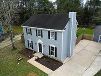 Charming two-story home featuring a gray exterior with black shutters and a well-manicured front yard at 12109 Sawtry Ct, Pineville, NC 28134