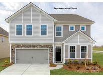 Charming two-story home with gray siding, stone accents, a two-car garage, and a manicured lawn at 132 Asmodean Ln, Troutman, NC 28166