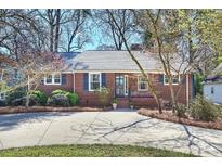 Charming brick home featuring a well-manicured lawn, classic shutters, and a welcoming front entrance at 138 Scofield Rd, Charlotte, NC 28209