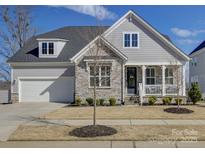 Charming home with stone accents, a well-manicured lawn, and a welcoming front porch at 14230 Morningate St, Huntersville, NC 28078