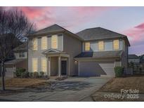 Charming two-story home featuring a well-manicured lawn, attached two-car garage, and traditional architectural details at 15317 Colonial Park Dr, Huntersville, NC 28078