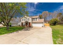 Charming two-story home with a spacious driveway, attached garage, and well-manicured lawn at 1812 Rosewell Dr, Rock Hill, SC 29732