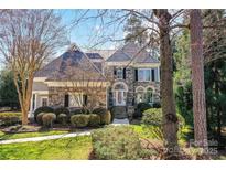 Stunning stone exterior with well-manicured landscaping, and a charming entrance, creating an inviting curb appeal at 18512 Square Sail Rd, Cornelius, NC 28031