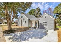 Well-maintained home with gray siding, mature trees, and a spacious driveway at 244 N Race St, Statesville, NC 28677