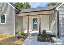 Inviting front entrance with charming blue door, 'welcome' sign, and manicured landscaping at 244 N Race St, Statesville, NC 28677
