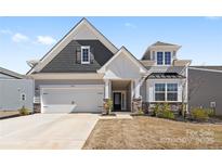 Charming home featuring a two-car garage and a welcoming front porch with stone and siding accents at 2953 Findley Rd, Statesville, NC 28625