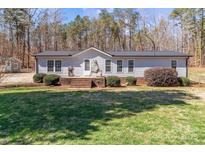 Charming one-story home featuring a cozy porch, well-maintained lawn, and mature trees at 345 Waccamaw Dr, Salisbury, NC 28146