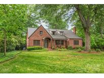 Charming brick home with lush green lawn and mature trees offering great curb appeal at 600 S Central Ave, Belmont, NC 28012
