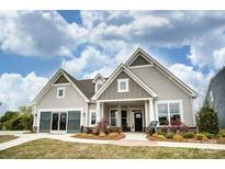 Charming single-Gathering home with stone accents, neutral siding, manicured lawn, and inviting, covered entryway at 1018 Heritage Pointe # 302, Indian Trail, NC 28079