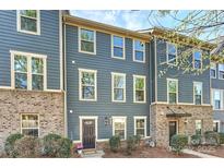 Charming townhome featuring a blue exterior, brick accents, and well-maintained landscaping at 1317 Queen Lyon Ct, Charlotte, NC 28205