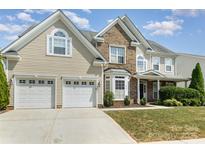 Charming two-story home featuring a two-car garage, brick accents, and a well-maintained lawn at 1615 Jekyll Ln, Waxhaw, NC 28173