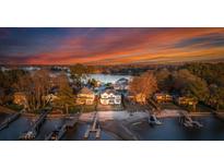 Stunning aerial view of waterfront property with docks and beautiful sunset at 20637 Island Forest Dr, Cornelius, NC 28031