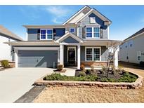 Beautiful two-story home featuring a two-car garage, well-maintained lawn, and stylish blue siding at 2085 Saddlebred Dr, Iron Station, NC 28080