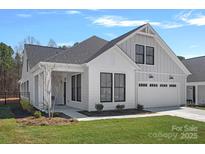 Beautiful home with white siding, black trim windows, well-manicured lawn, and attached two car garage at 218 Alenda Lux Cir, Mooresville, NC 28115