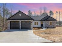 A charming single-story home with a stone and gray shingle accent and a two car garage at 24 Eastwinds Dr, Hickory, NC 28601
