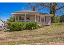 Quaint, light grey home with a covered front porch and mature landscaping at 405 Link St, Fort Mill, SC 29715