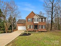 Charming brick home with a well-manicured lawn and a two-car garage, perfect for Gathering living at 670 Sherwood Pl, Mooresville, NC 28115