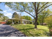 Charming ranch-style home with a spacious front yard and mature trees at 7212 Hackberry Ln, Charlotte, NC 28226