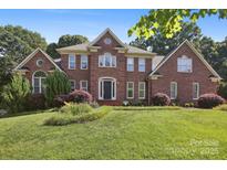 Imposing two-story brick home with a manicured lawn and mature landscaping at 8011 Greencastle Dr, Charlotte, NC 28210