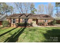 Charming brick home with a well-maintained lawn and mature trees in a tranquil setting at 8817 Tree Haven Dr, Charlotte, NC 28270