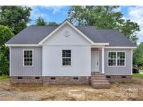 Charming exterior view of a single-story home with gray and white siding and brick foundation at 914 Saluda St, Rock Hill, SC 29730