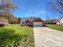 Charming brick home with attached garage and manicured lawn at 1025 Ridgefield Cir, Indian Trail, NC 28079