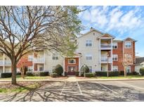 Inviting multi-story condo building featuring balconies, brick accents, well-maintained landscaping, and accessible parking at 10663 Hill Point Ct, Charlotte, NC 28262