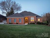 Charming brick home featuring a well-manicured lawn, mature landscaping, and a welcoming front entrance at 110 49Th Avenue Nw Pl, Hickory, NC 28601