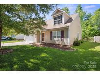 Charming home boasts a well-manicured lawn, inviting entrance, and attached garage, perfect for suburban living at 1219 Catawba Run Rd, Lowell, NC 28098