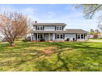 Charming two-story home with a well-maintained lawn, beautiful tree, and inviting front porch at 1448 Morrocroft Trl, Gastonia, NC 28054